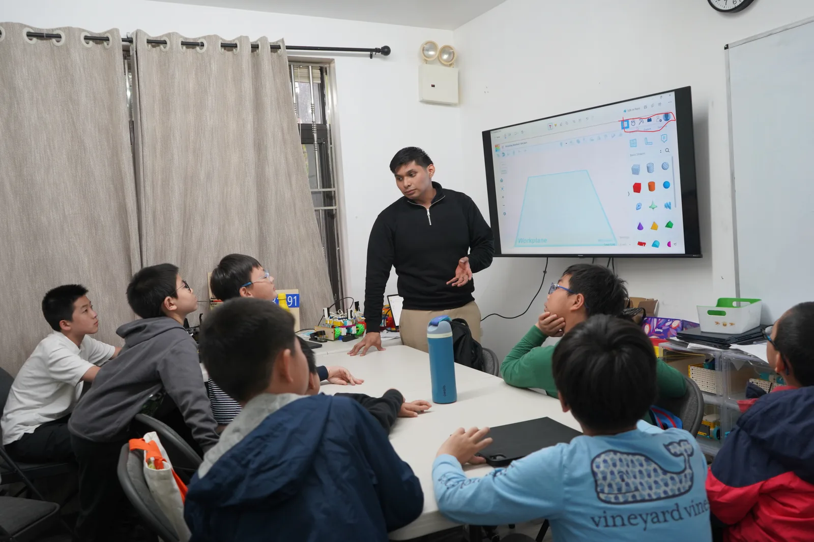 AI Future instructor teaching a small group of students during a hands-on STEM class